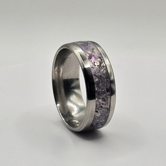 Silver ring with embedded stones on a light gray background