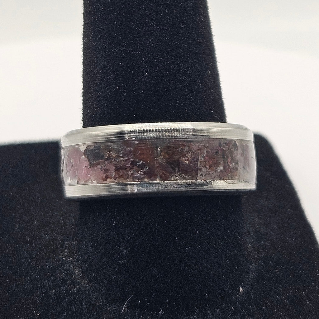 Silver ring on a black stand against a white background