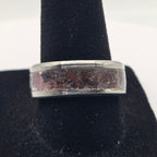 Silver ring on a black stand against a white background