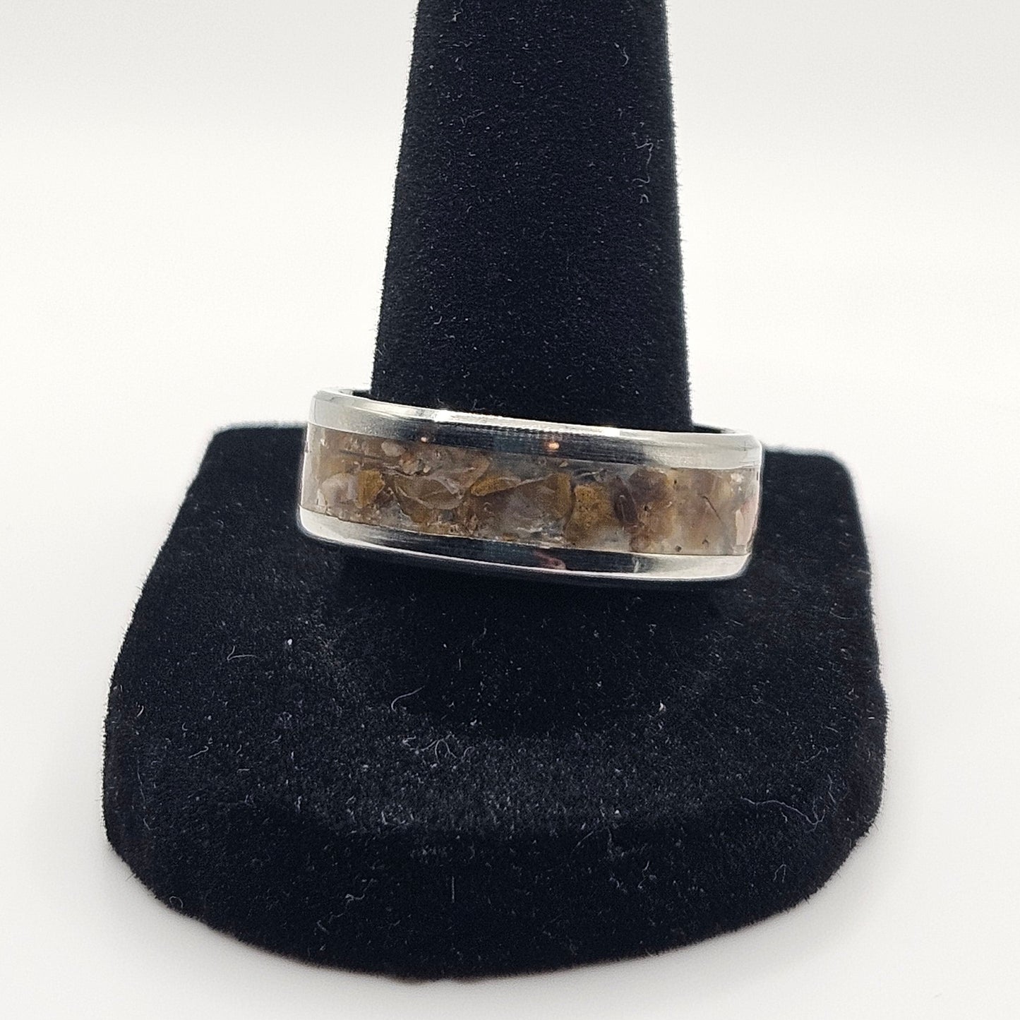 Silver ring on a black stand against a white background