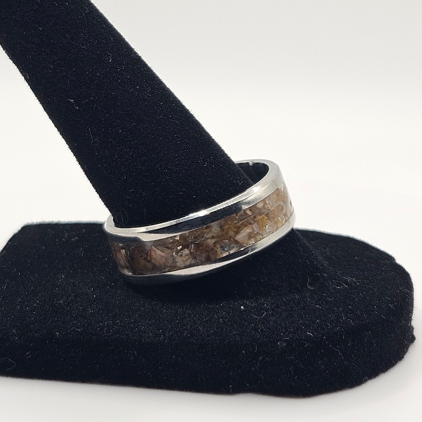 Silver ring on a black stand against a white background