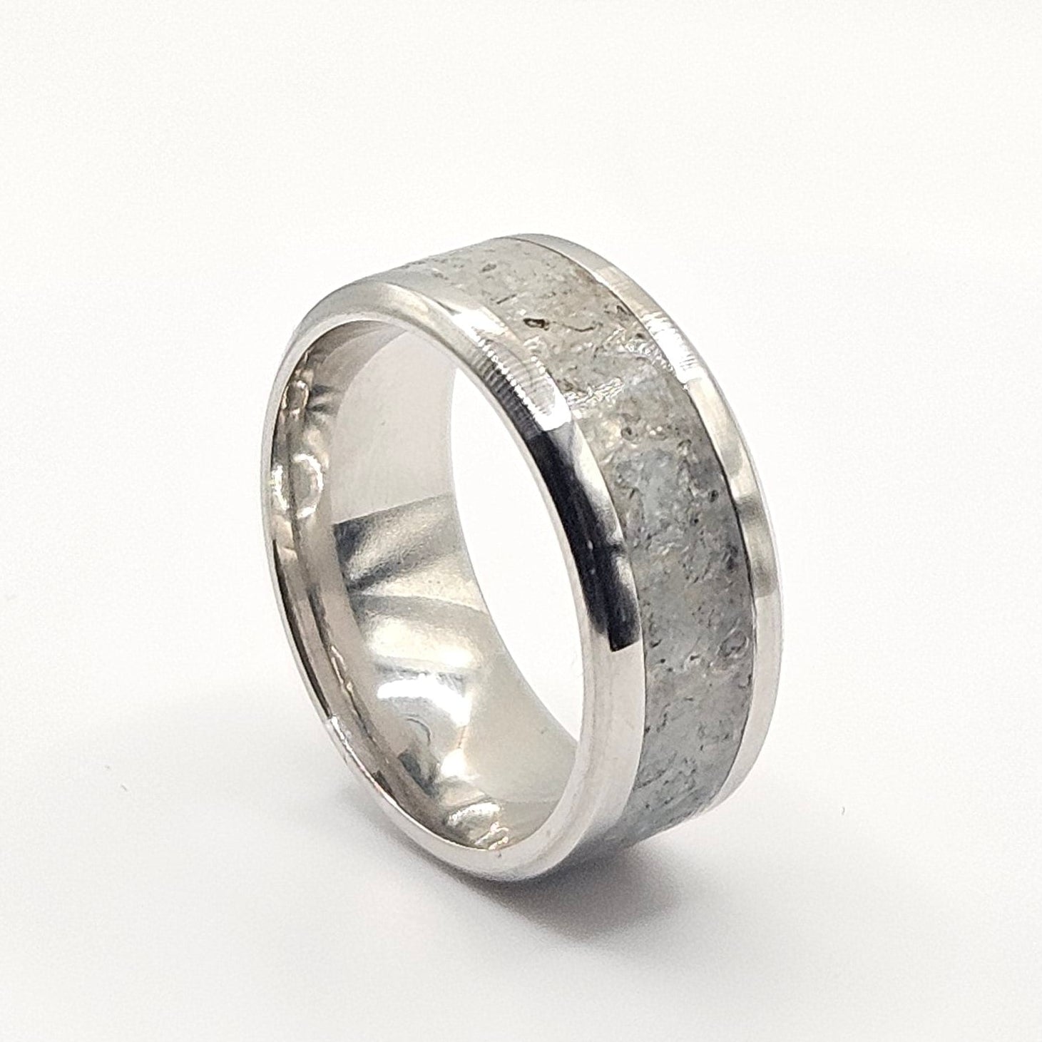 Silver ring with a textured band on a white background