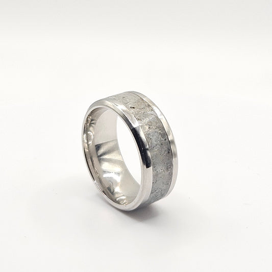 Silver ring with a textured band on a white background