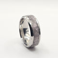 Silver ring with a textured surface on a white background