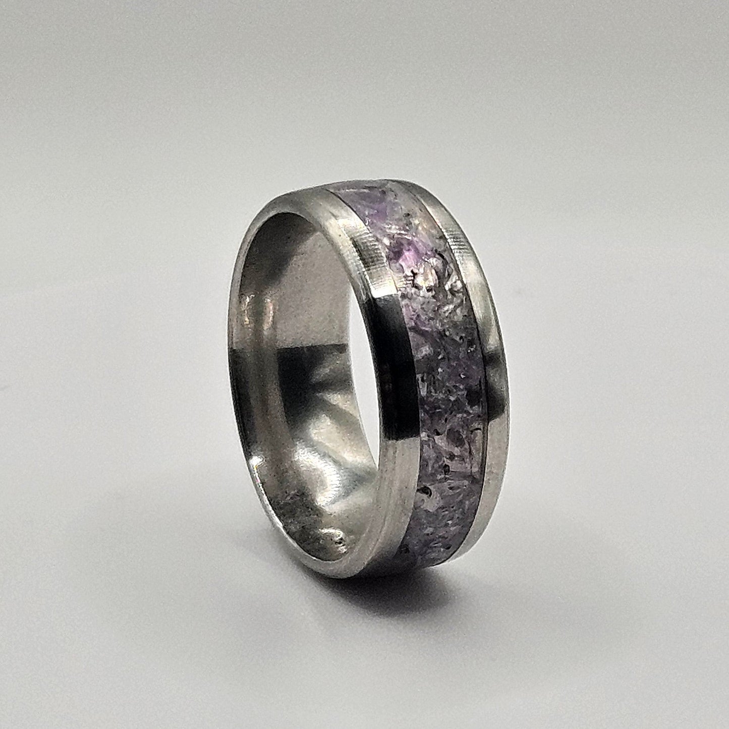 Silver ring with embedded stones on a light gray background