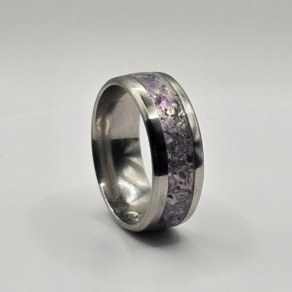 Silver ring with embedded stones on a light gray background