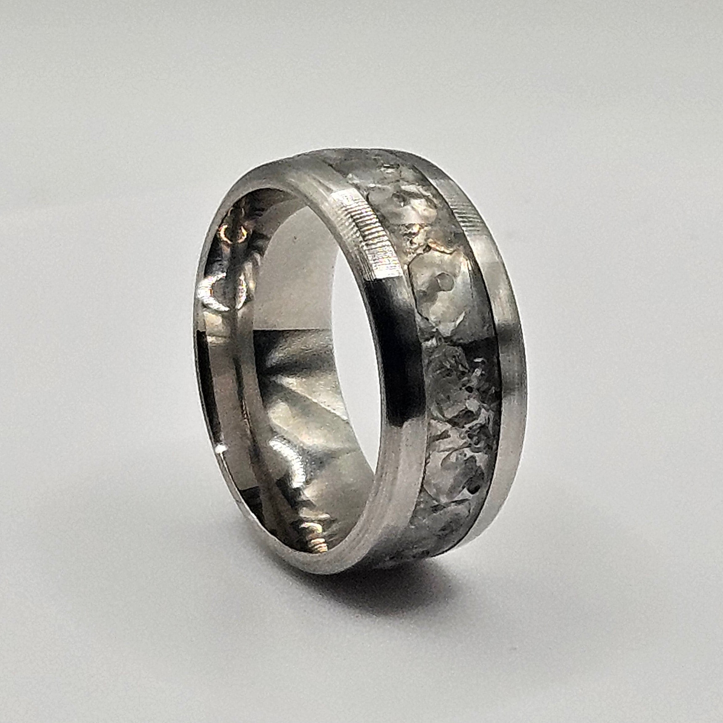 Silver ring with embedded stones on a light gray background