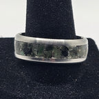 Silver ring on a black velvet stand against a white background