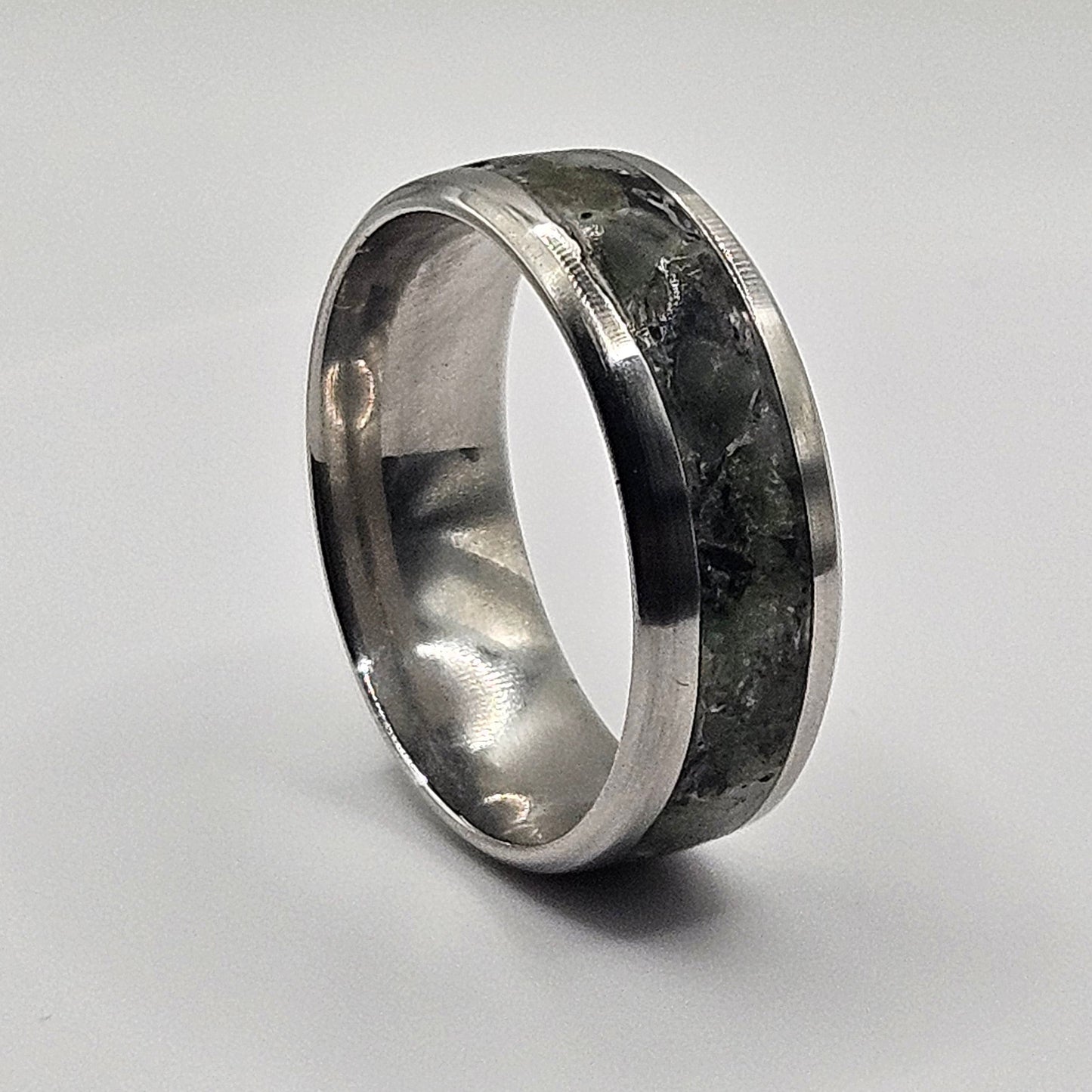 Silver ring with a textured band on a light gray background