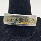Silver ring with embedded stones on a black velvet stand