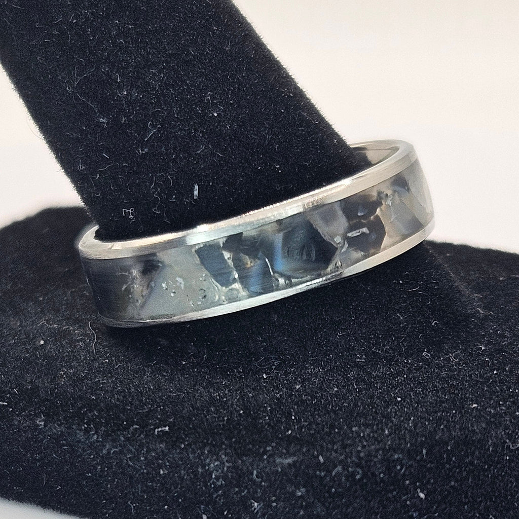 Silver ring on a black stand with a white background