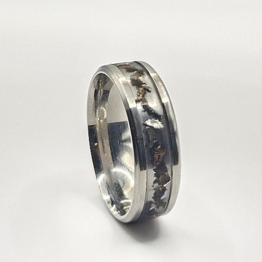 Silver ring with engraved design on a white background